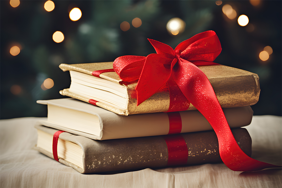 A stack of festive books with a red ribbon and a knitted blanket, christmas atmosphere