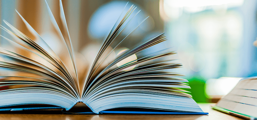 Light blue covered opened book lying on the table in a library