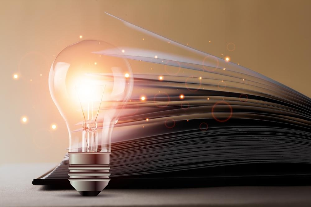 woman in glasses sitting on the couch browsing on a tablet device